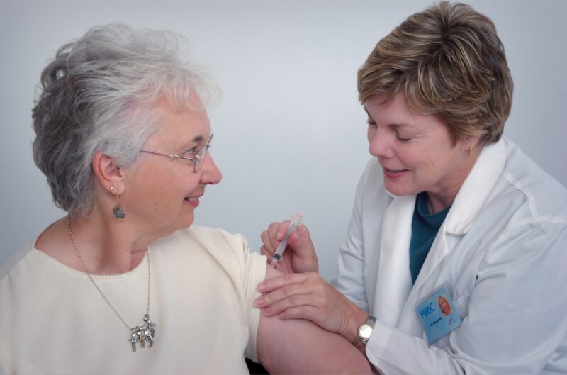 Doctor Administering Vaccine to Elderly Patient