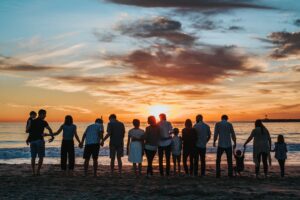 Group of Happy People on Beach at Sunset
