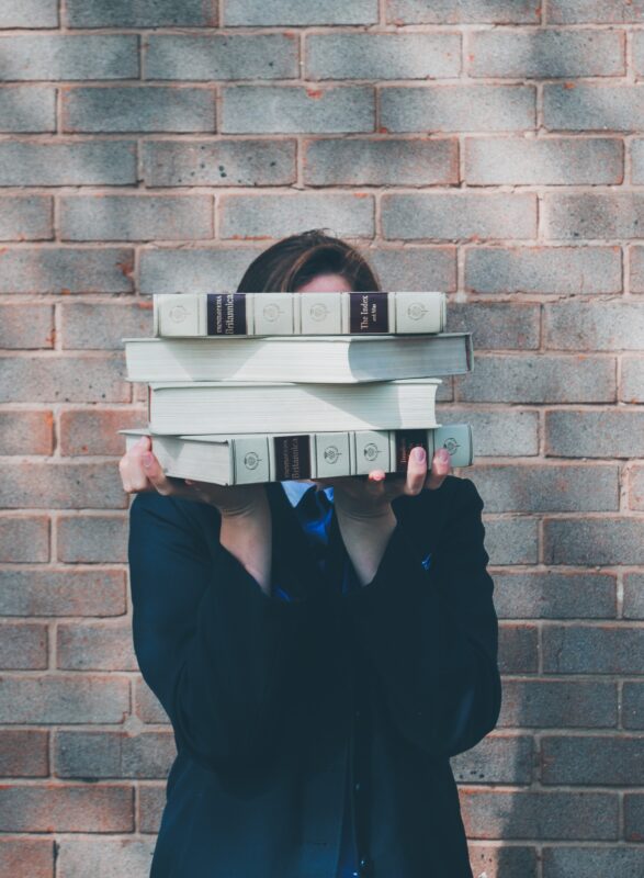 Person Holding Stack of Medical Books