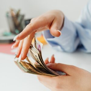 person-holding-silver-and-gold-colored-money