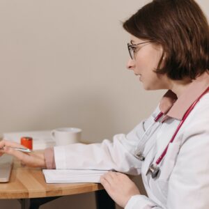 physician-in-white-coat-using-her-laptop