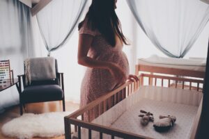 pregnant-woman-looking-at-crib