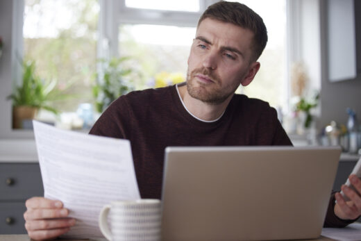 Man comparing affordable health insurance options for unemployed individuals on computer.