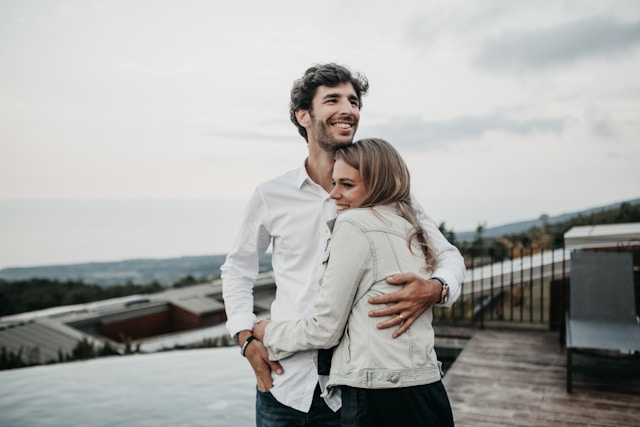 Newly married couple standing together outdoors, reviewing life changes like health insurance after marriage