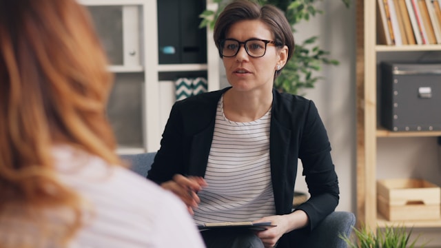 Therapist talking with a patient during a counseling session, illustrating the importance of choosing the right health insurance for mental health.
